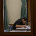 英検準2級プラスを検討しながら机で学習する生徒