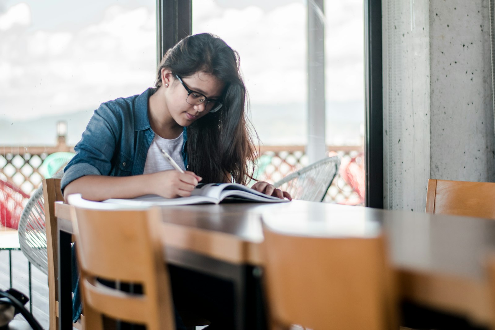 ノートに向かって学習する女性（イメージ写真）